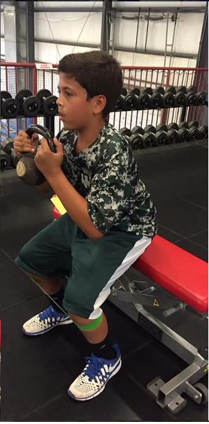 Small boy undergoing strength training